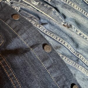 Contrasting denim jackets, one worn over the other. A vintage jacket overlaid with a blue indigo one