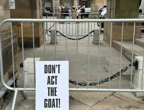A protest poster created by Ali Campbell in a classic style, black on white, bold text. The text reads 'Don't Act The Goat!'