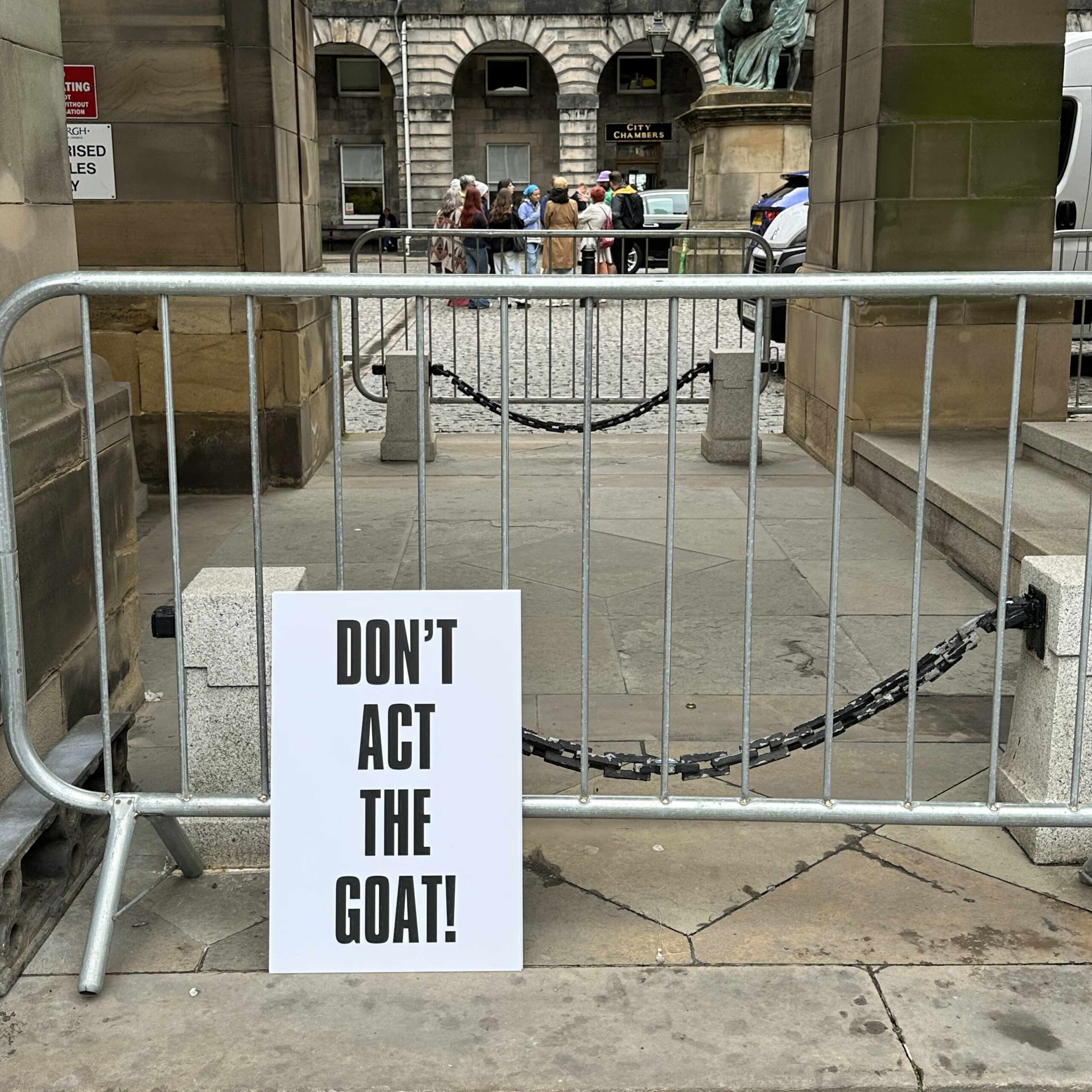 A protest poster created by Ali Campbell in a classic style, black on white, bold text. The text reads 'Don't Act The Goat!'